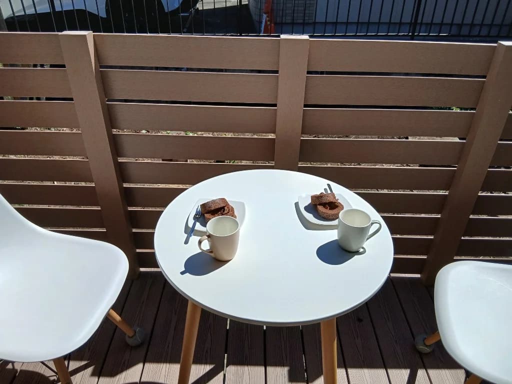 ウッドデッキでコーヒーとおやつを楽しむテーブルセット